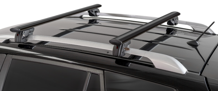 deux barres de toit noires fixées sur un véhicule avec des barres d'origine