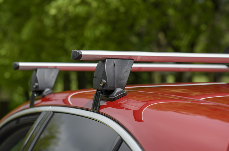 deux barres de toit grises fixées par machoire sur un véhicule rouge