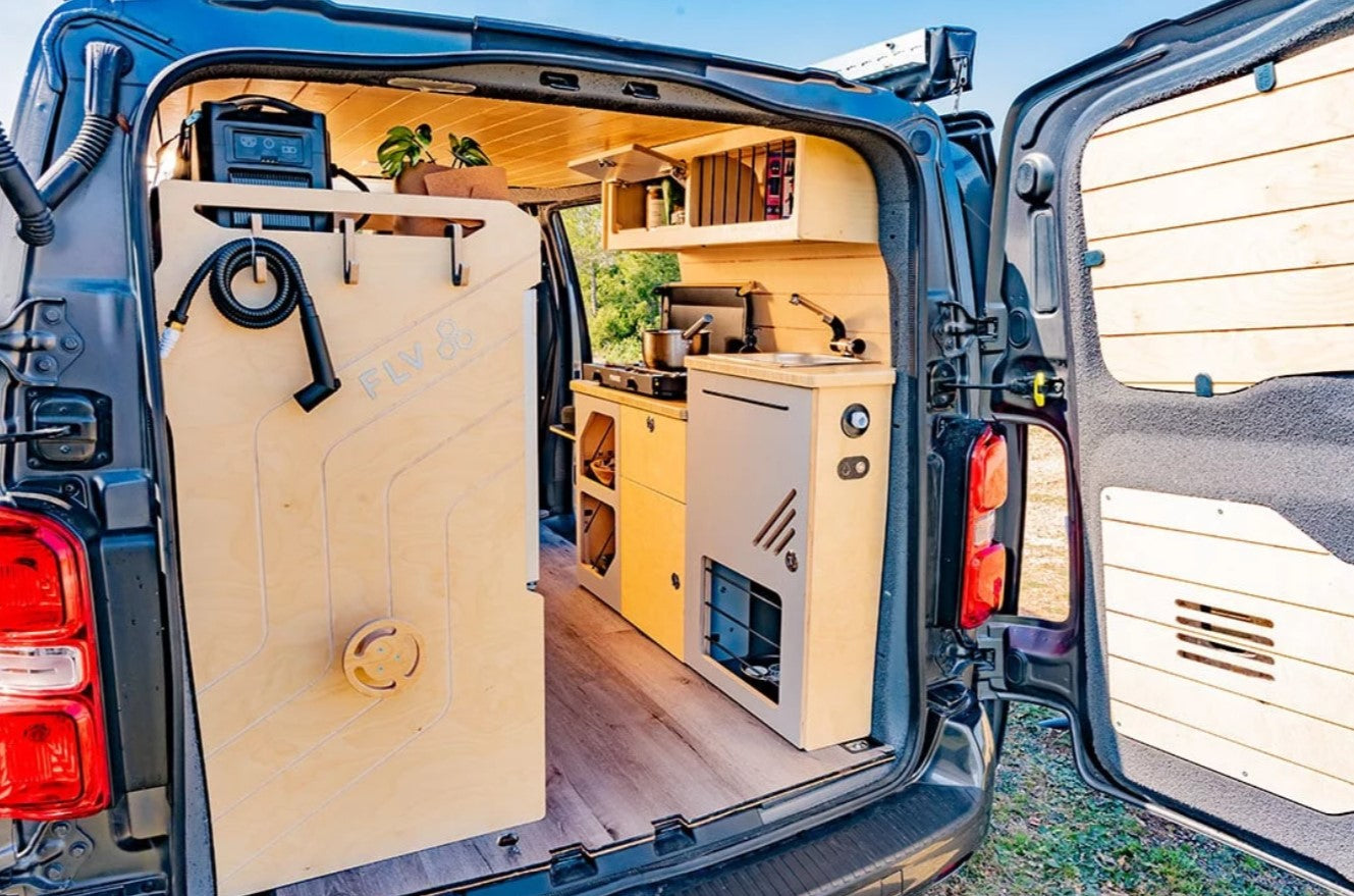 intérieur d'un van aménagé avec un espace cuisine et évier