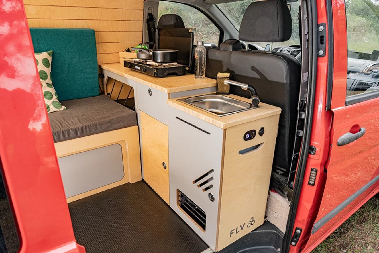 Intérieur d'un fourgon aménagé avec un module cuisine et évier