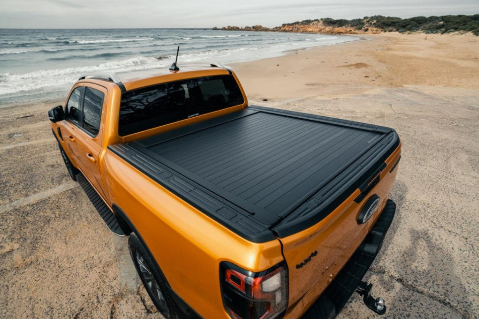 Ford Ranger orange sur la plage avec un couvre-brenne noir