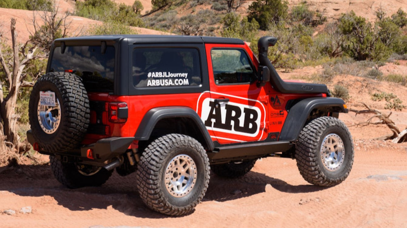 Jeep wrangler JL rouge dans le désert avec un gros logo ARB