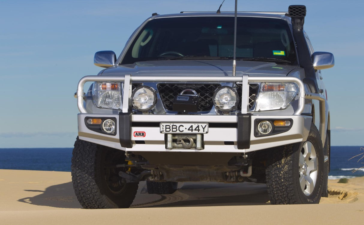 Nissan Pathfinder R51 gris dans le désert avec un pare-chocs ARB