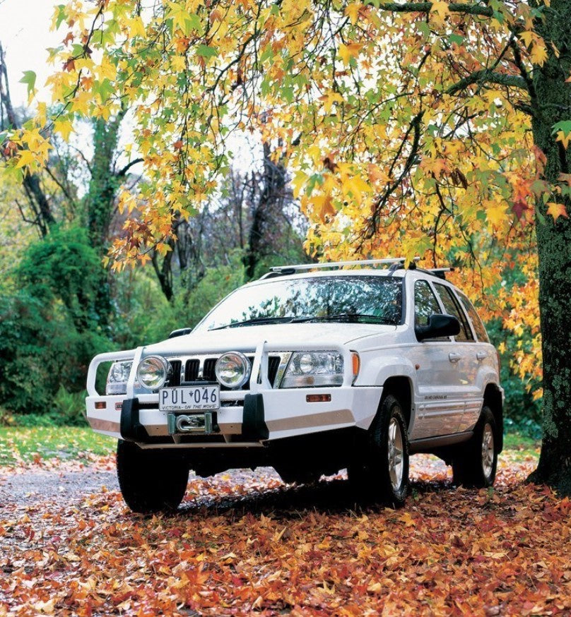 Jeep Grand Cherokee avec un pare-chocs ARB blanc dans des feuilles