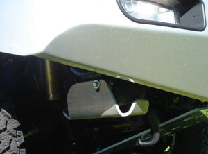 vue latérale d'un véhicule à l'avant avec une pièce métallique sous le pare-chocs
