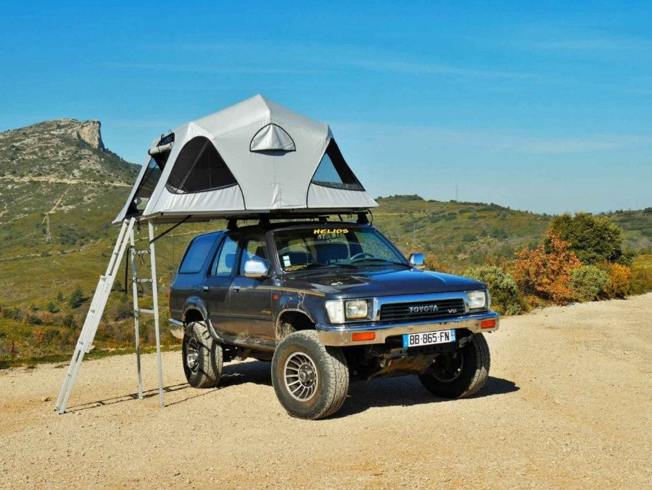 Toyota V8 devant une colline avec une tente de toit