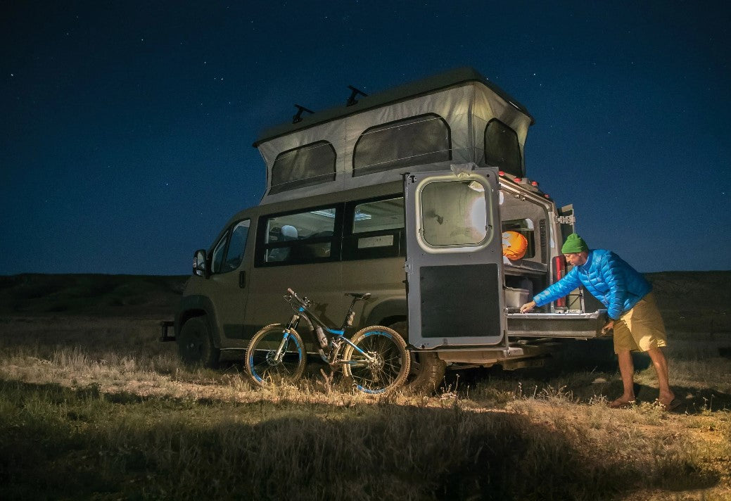 véhicule garé dans la nuit équipé pour le voyage avec un vélo