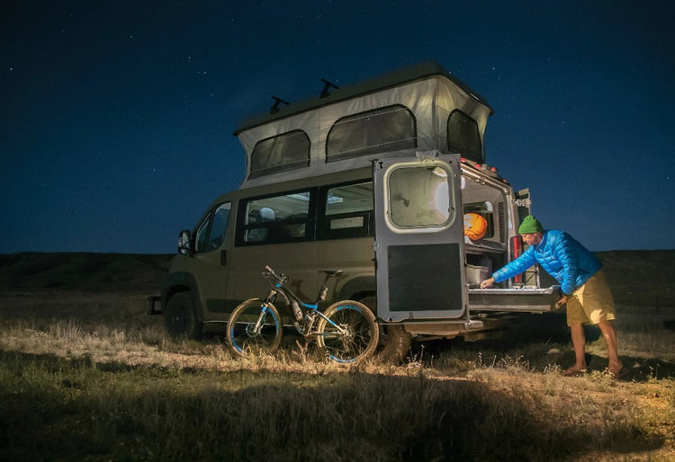 véhicule garé dans la nuit équipé pour le voyage avec un vélo