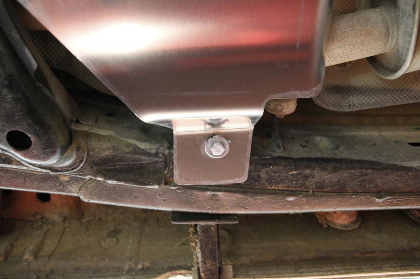 extrémité d'une protection alu boulonnée sous le véhicule