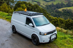 volkswagen transporter devant un paysage de collines verdoyantes