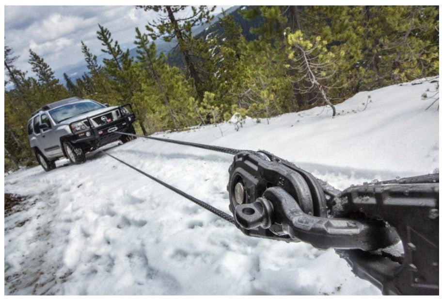 Nissan dans la neige tracté par un treuil fixé sur manille warn
