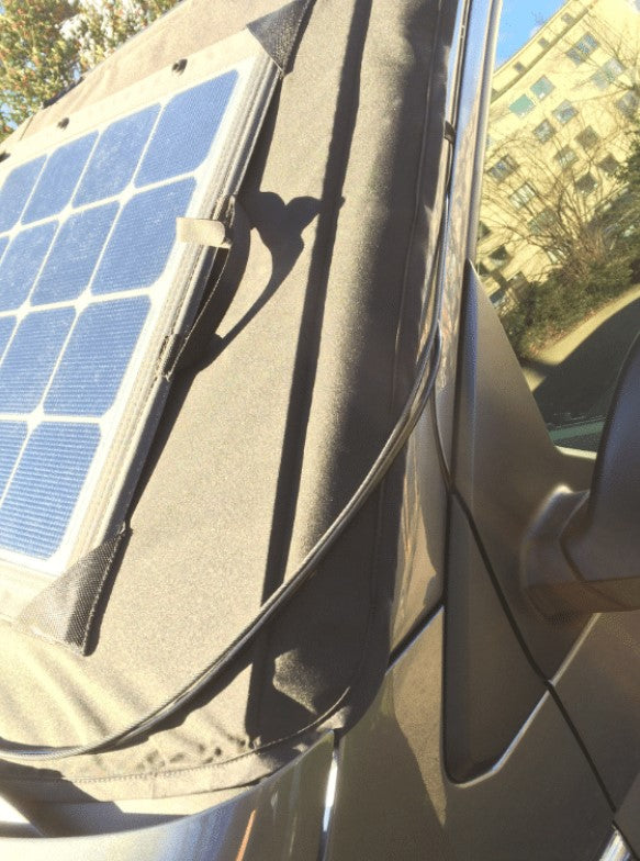 Vue latérale avant d'un véhicule avec une couverture pare brise solaire