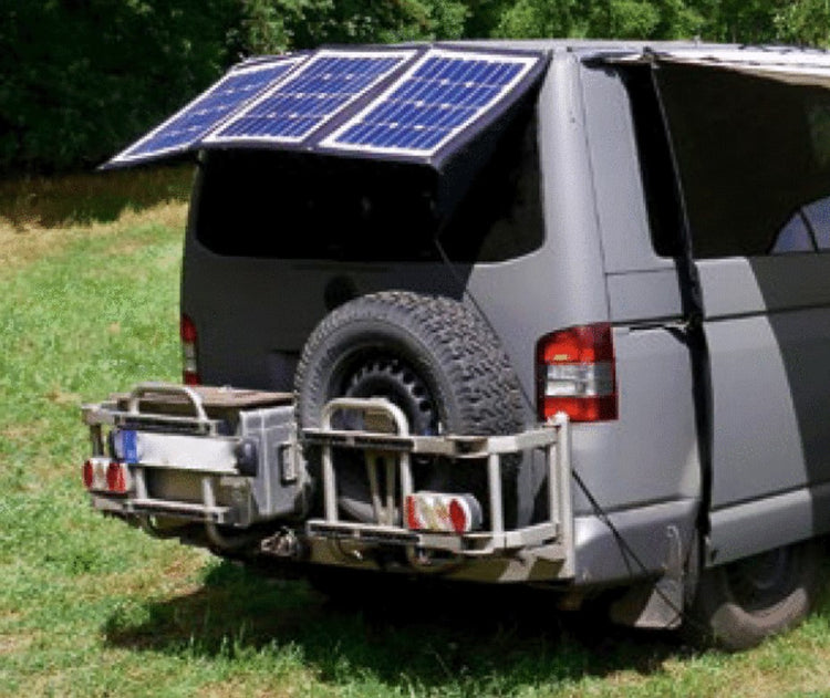 vue arrière d'un transporter dans l'herbe avec porte roue et panneau solaire arrières