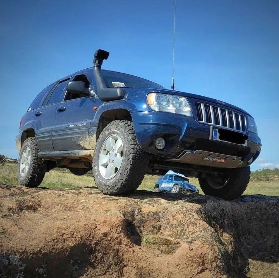 Jeep Grand Cherokee WJ/WH bleu sur de la roche avec une protection Almont