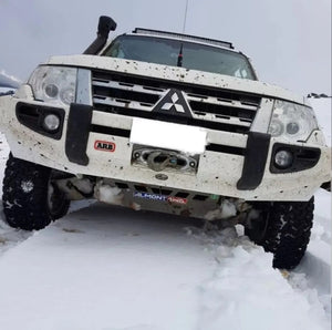 Pajero blanc dans la neige avec un pare-chocs arb et une protection moteur