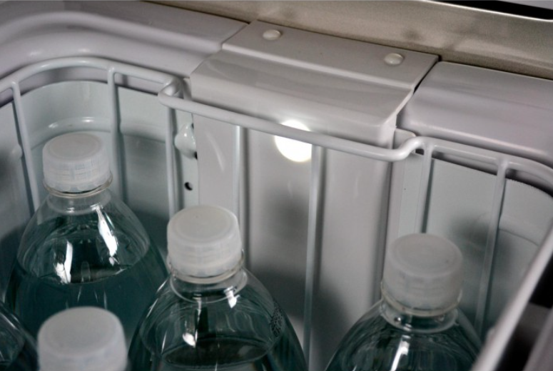 intérieur d'un frigo engel avec des bouteilles d'eau