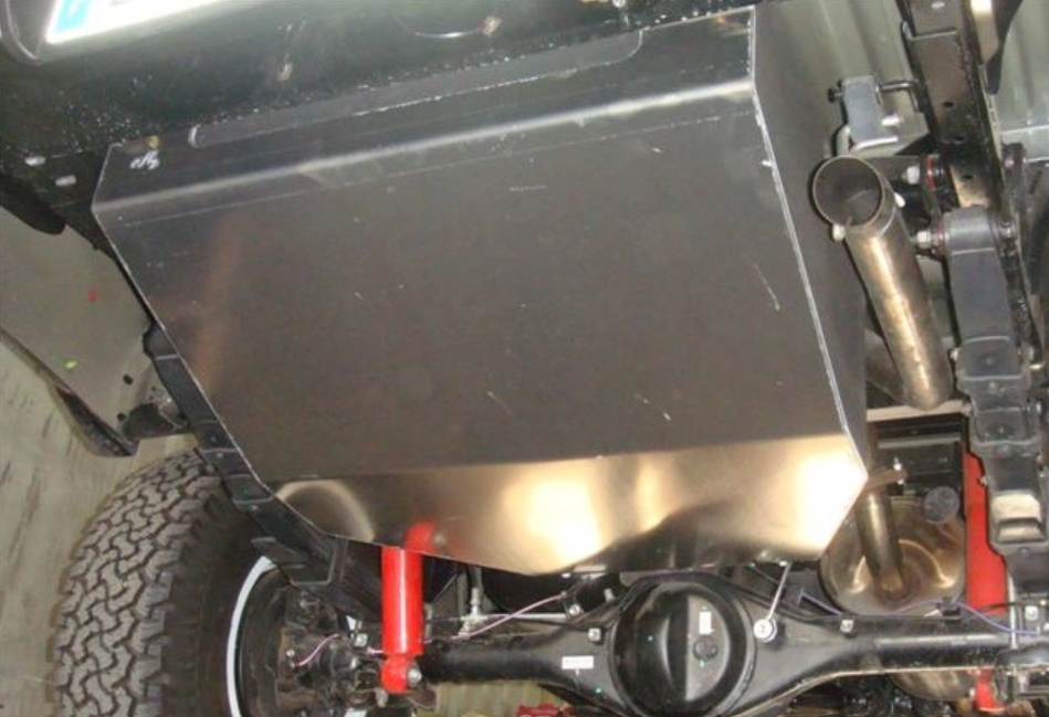 réservoir acier monté sous un véhicule avec des amortisseurs rouges