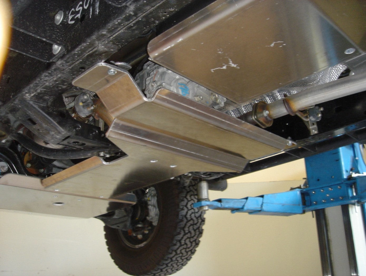 vue latérale du dessous d'un véhicule avec des plaques de protection alu