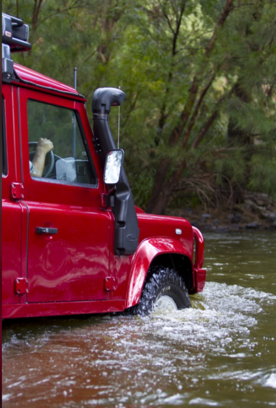 Defender 90 rouge dans de l'eau avec un snorkel