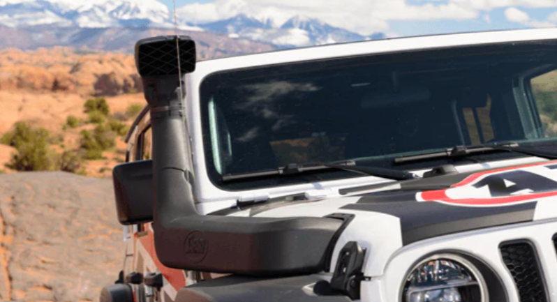 vue de face d'une jeep avec un snorkel et un paysage de montagne