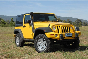 jeep wrangler diesel jaune avec un snorkel, dans un paysage vert