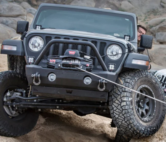 Jeep wrangler noir tractée par un treuil warn